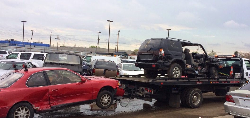 Flatbed Tow Truck Hauling A Vintage Car And Wreck