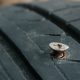 Close up of a metal screw that punctured the car tire.