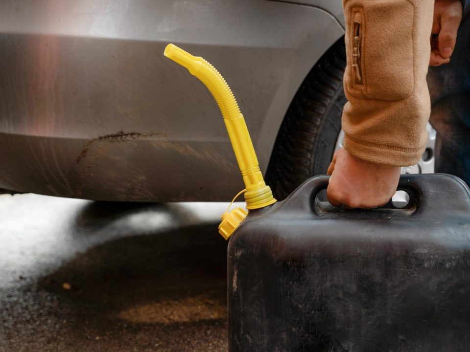 man holding a jerry can filled with car fuel